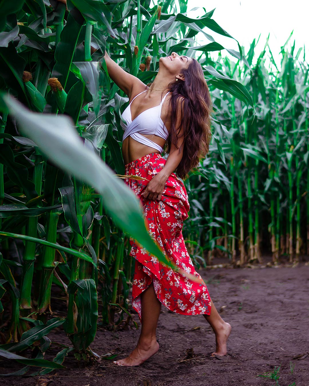 Junge Frau mit roten Rock im Maisfeld bei einem Portrait Fotoshooting