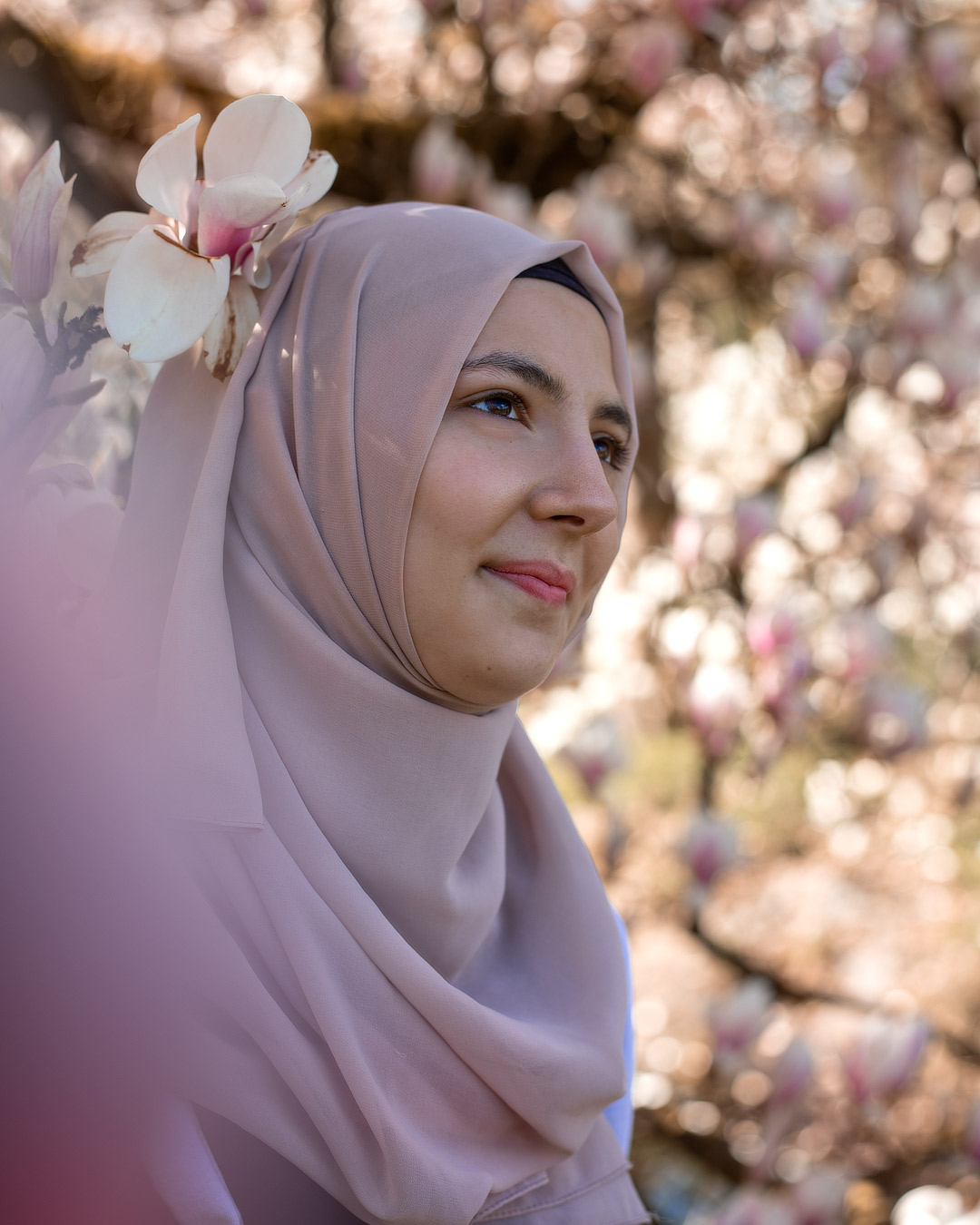 Portraitfoto junge Frau zwischen Magnolienblüten