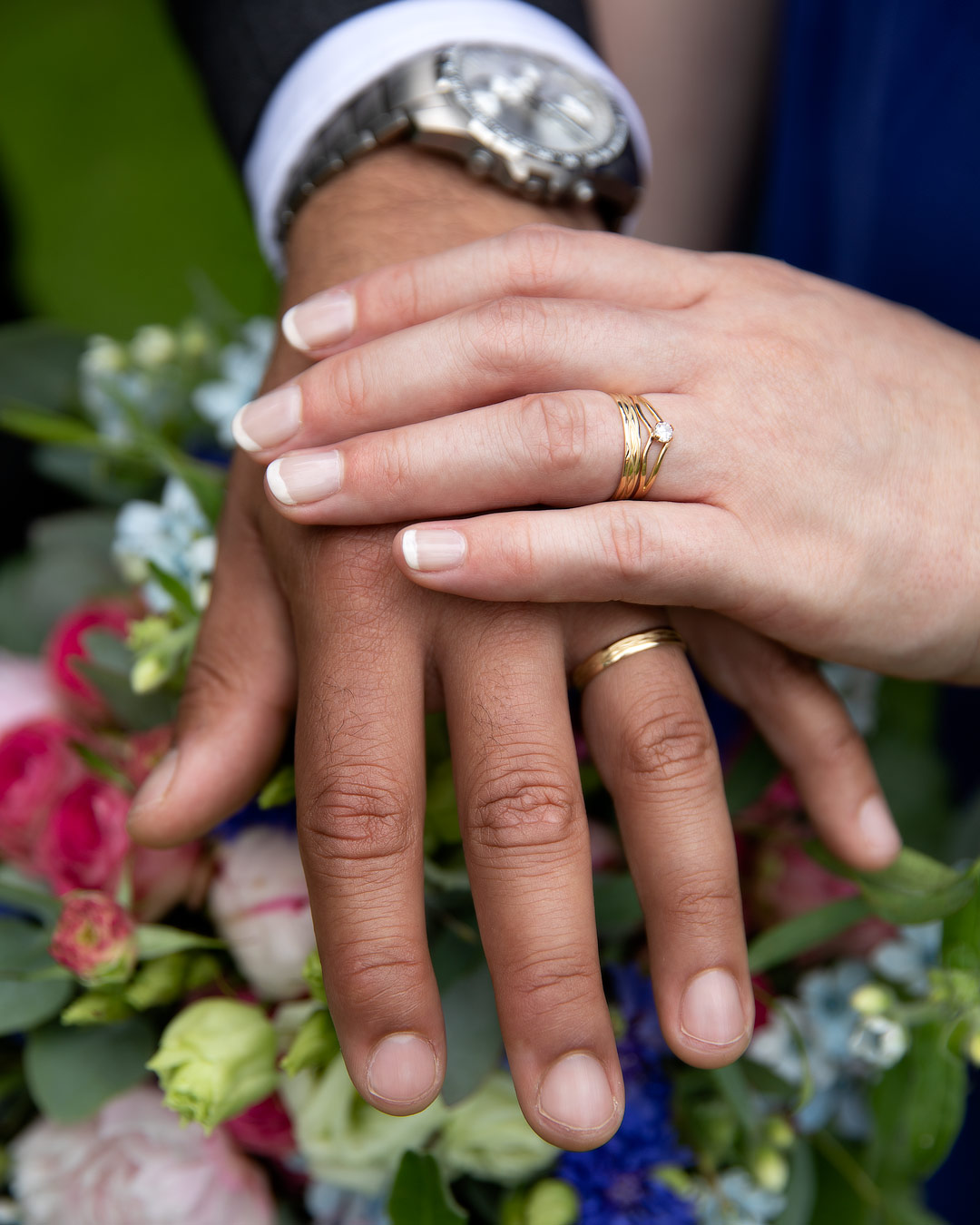 Hochzeit Brautpaar Eheringe an der Hand auf einem Blumenstrauß