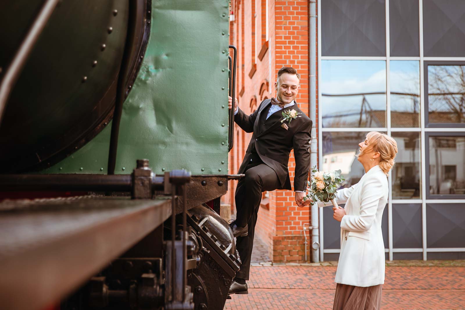 Brautpaar macht Hochzeitsfoto an alter Lokomotive