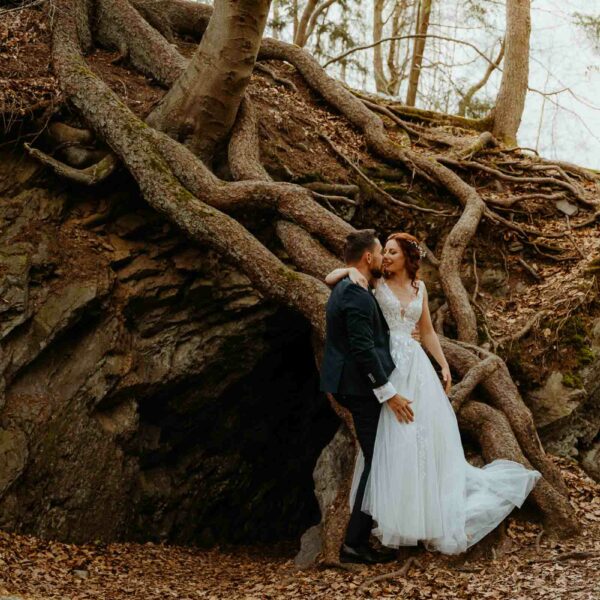 Elopement im Harz Hochzeit zu Zweit im Harz Brautpaar steht vor den Wurzeln eines großen Baumes