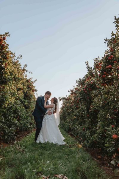 Hochzeitsfotograf Hamburg Hochzeit Altes Land Paar steht zwischen Apfelbäumen