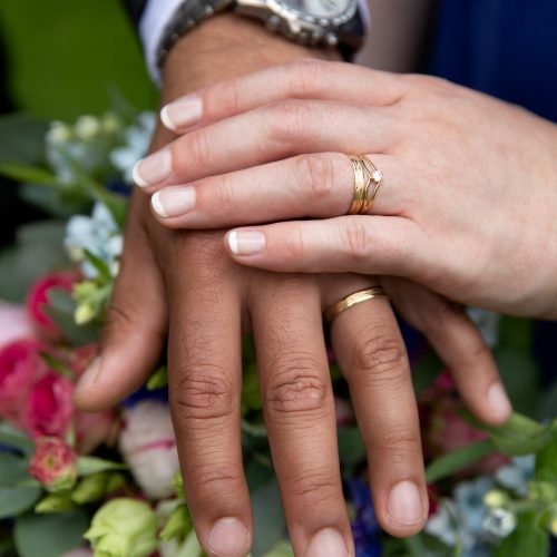 Hochzeit Brautpaar Eheringe an der Hand auf einem Blumenstrauß