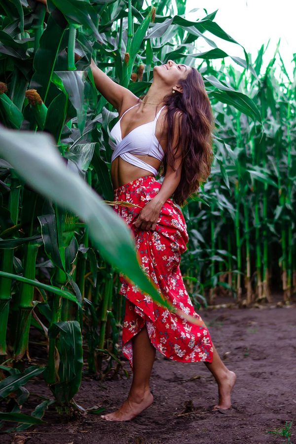 Junge Frau mit roten Rock im Maisfeld bei einem Portrait Fotoshooting