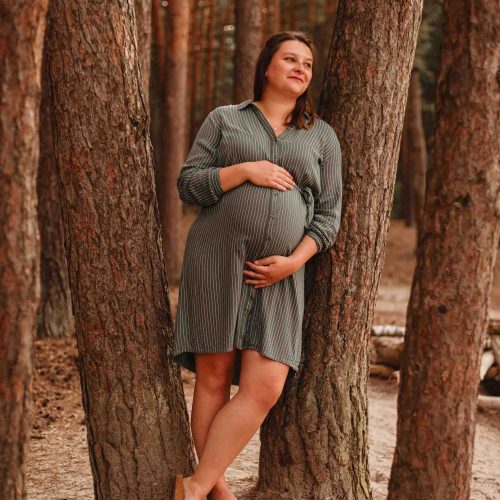 Schwangerschaftsfotos im Wald Schwangere steht an Baum angelehnt Babybauchfotos